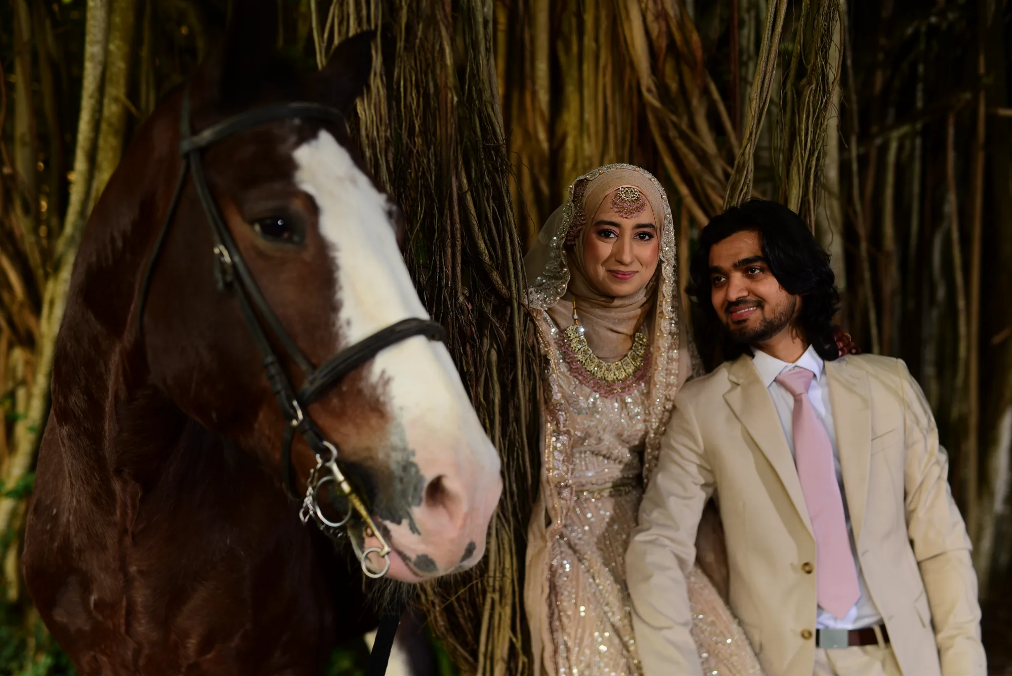 Shabneez and Noman photographed beside a horse in front of the banyan roots at Mon Choisy Le Golf after their Nikkah